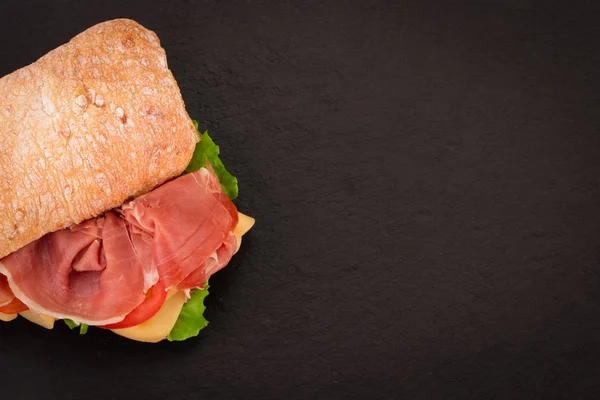 Ciabatta sandwich met sla, prosciutto en kaas over Sto — Stockfoto