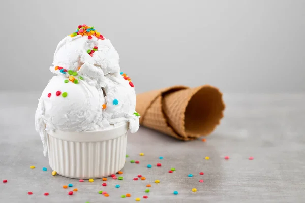 Talíř vanilkové zmrzliny s posytkami a vaflovým kuželem — Stock fotografie