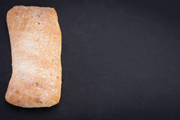 Ciabatta chleba na ciemnym tle, widok z góry z kosmosu — Zdjęcie stockowe