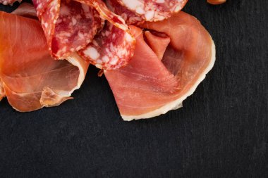 İtalyan prosciutto Crudo veya İspanyol Jamon ve sosis. Taş kesme tahtasında çiğ jambon