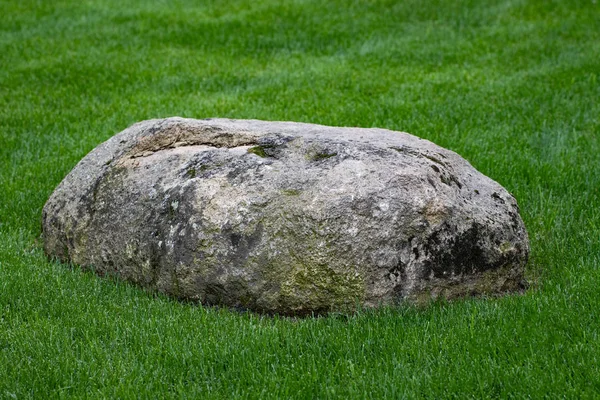 Big stone lying on the green grass — Stock Photo, Image