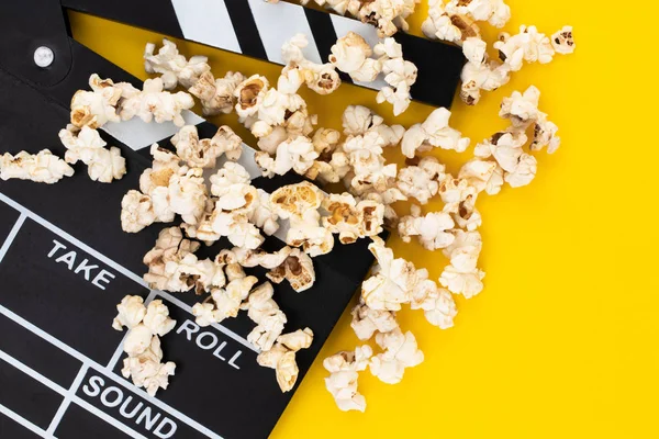 Popcorn a prkno na barevném pozadí. Horní pohled. — Stock fotografie