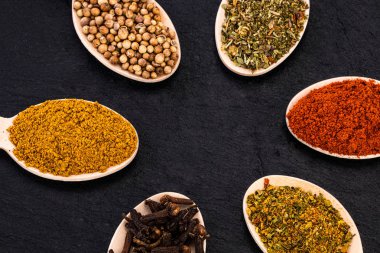 Koyu arkaplanda renkli bitkiler ve baharatlar. Üst görünüm