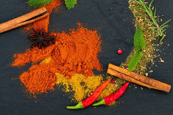 Várias especiarias coloridas em fundo escuro — Fotografia de Stock