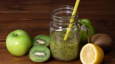Ahşap arka planda yeşil elma ve kivi ile karıştırılmış yeşil smoothie..