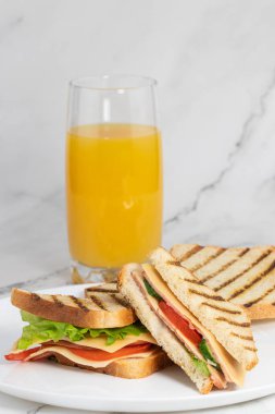 Hafif arka planda peynirli ve meyve suyu olan tostlu kahvaltı..