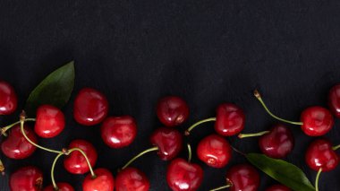 Koyu arkaplanda fotokopi alanı olan bir kiraz. Üst Manzara. Düz yatıyordu.