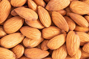 Badem arkaplan dokusu. Rastgele yerleştirilmiş çiğ badem fıstığının arka planı.