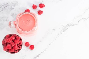 Cam bir kavanozda ahududu püresi ve taze ahududu. Üst görünüm, alanı kopyala.