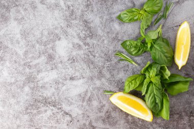 Taş zeminde bitki ve baharat seçimi. Biberiye, fesleğen ve limon. Üst görünüm.