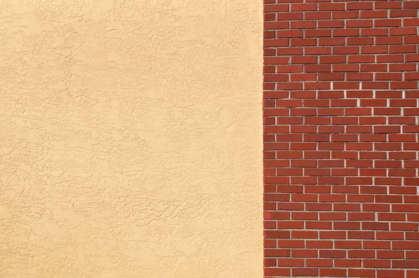 一个空白的空黄色灰泥墙连接到一个红砖墙 — 图库照片