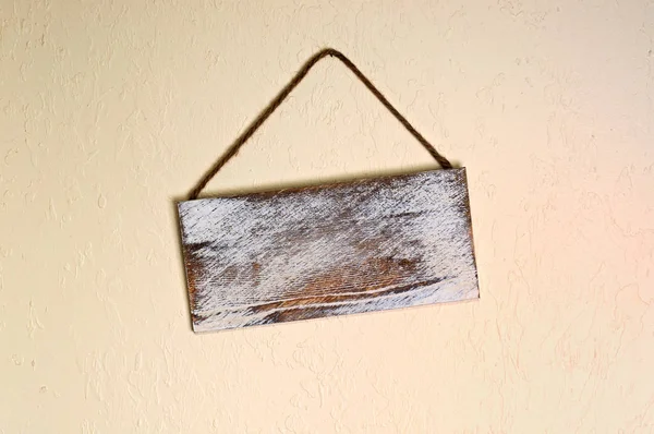 blank old wooden sign hanging crooked on wall