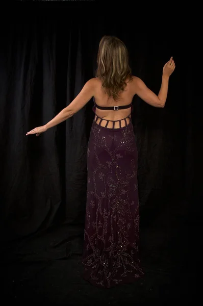 派手なドレスで後ろから彫像のように立っているブロンドの女性 — ストック写真