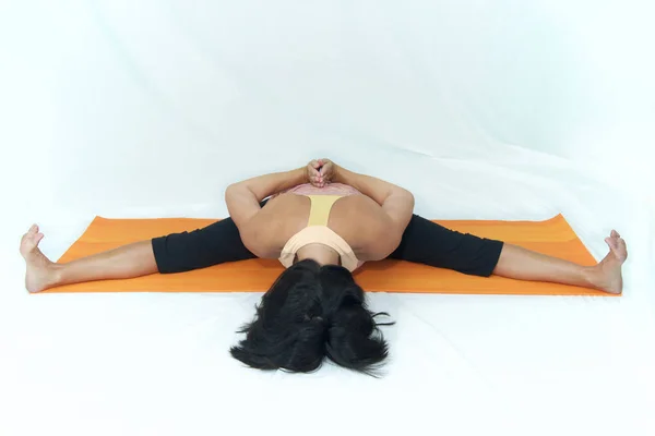 Vrouw in voorwaartse vouwen omgekeerde gebed yoga pose op witte backgrou — Stockfoto