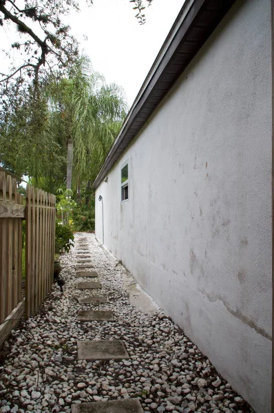 Kamienny zadaszony aleja obok dom z tropikalny roślina — Zdjęcie stockowe