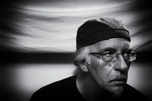 Чорно-білий портрет людини в окулярах, який виглядає стурбованим — стокове фото