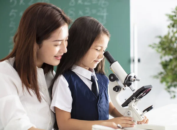 Teacher Helps Child Conduct Experiment Microscope — Stock Photo, Image