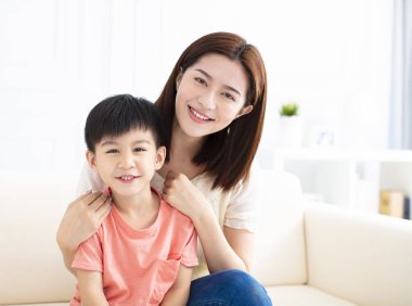 Anne ve oğlu kanepeye gülümseyen 