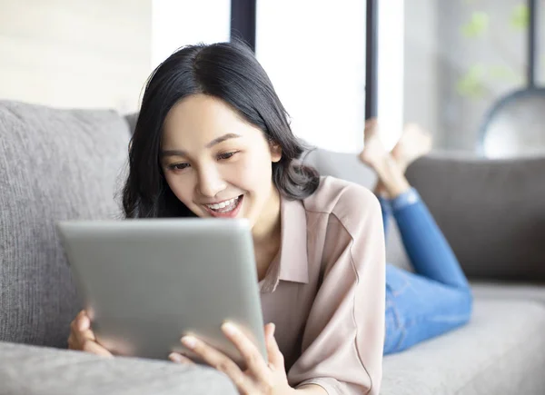 Jovem Feliz Com Tablet Deitado Sofá — Fotografia de Stock