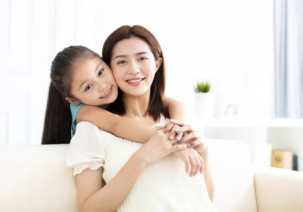 Mother and daughter smiling on couch