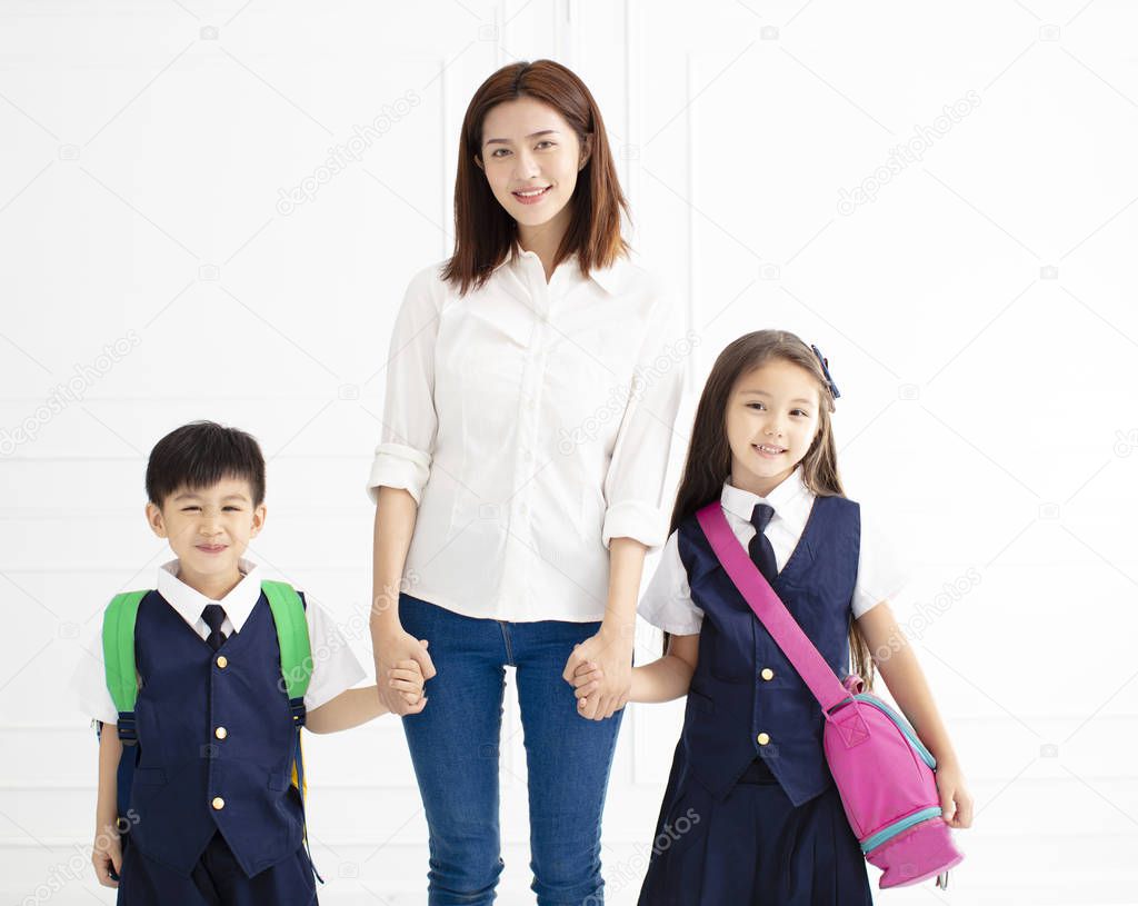 Mother holding hand of children ready go to school 