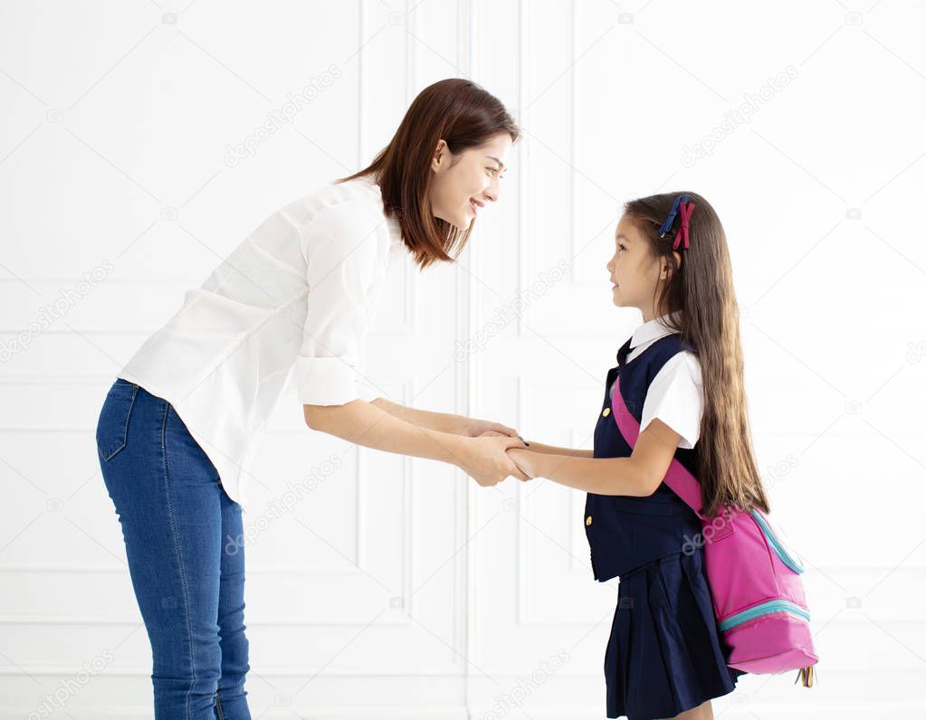 Mother holding hand of daughter ready go to school 