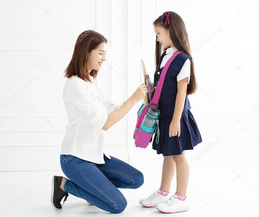mother and daughter preparing backpack for school