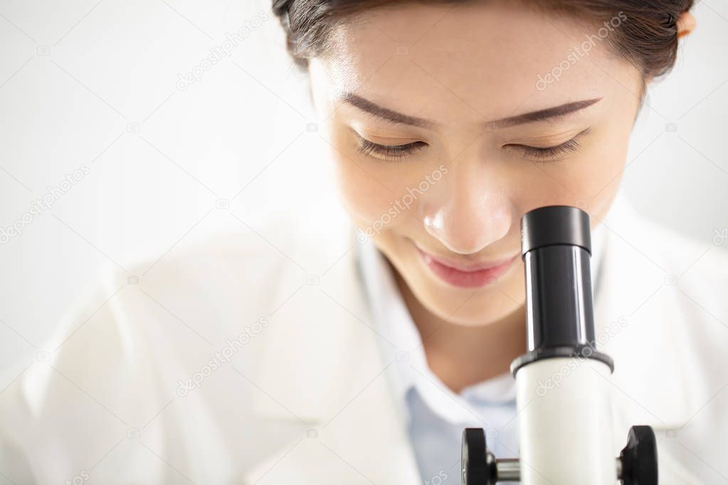 female medical or scientific researcher watching the microscope 