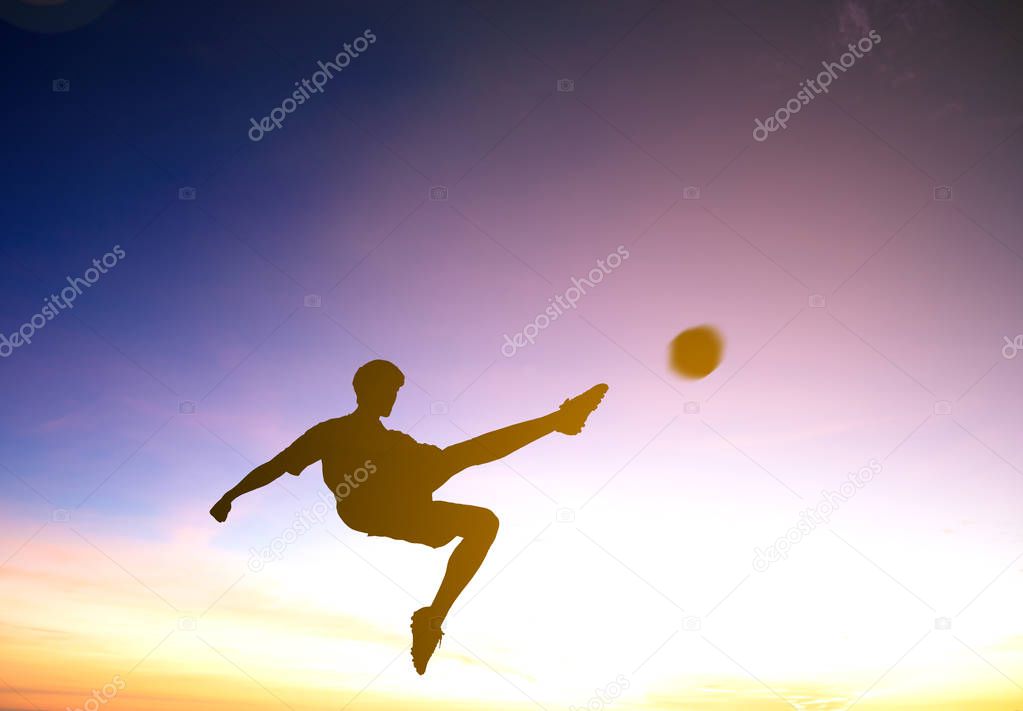 Silhouette of soccer player kicks ball  with sunset background