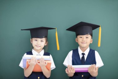 Mutlu erkek ve kız sınıfta mezuniyet şapkalı