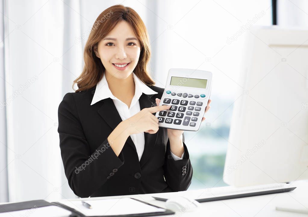 smiling business woman showing the calculator in office
