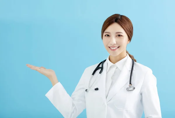 Médico Femenino Sonriente Señalando Con Dedo Sobre Fondo Azul — Foto de Stock