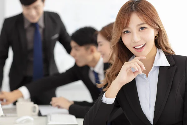 ビジネスの女性の背景に同僚と笑みを浮かべてください — ストック写真