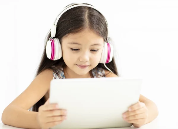 微笑的女孩在耳机和使用平板电脑 — 图库照片