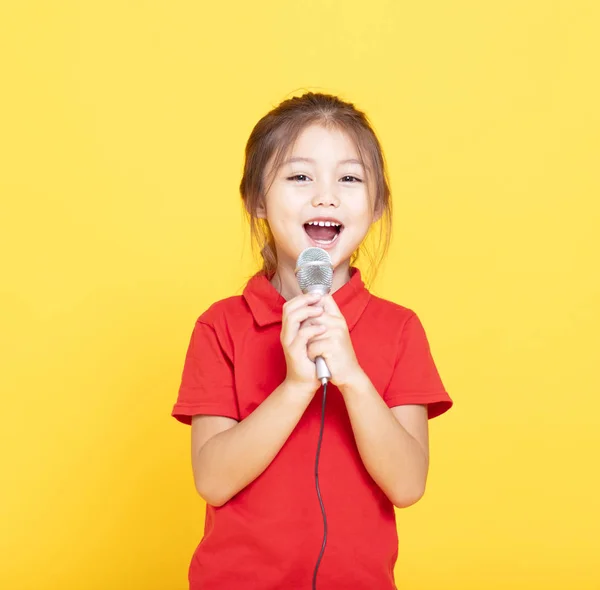 Fröhliches Kleines Mädchen Singt Auf Gelbem Hintergrund — Stockfoto