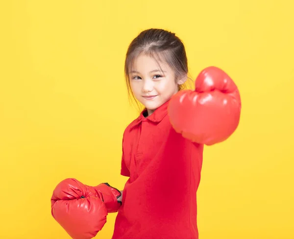 黄色の背景に赤のボクシング グローブでの幸せな女の子 — ストック写真