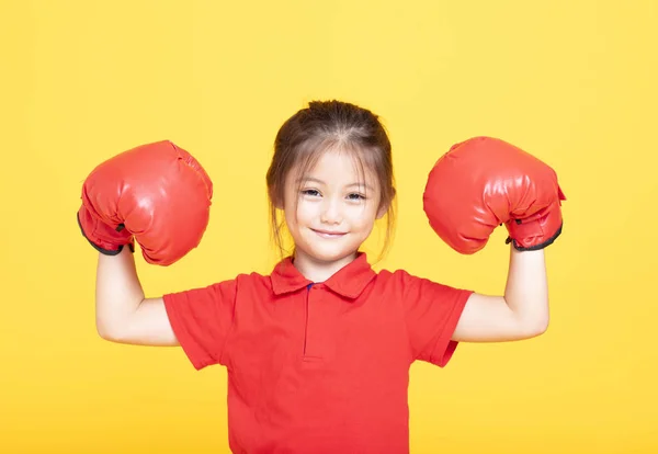 黄色の背景に赤のボクシング グローブでの幸せな女の子 — ストック写真