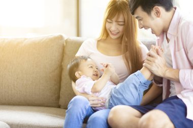 mutlu aile annesi ve babası evde bebekle oynarken