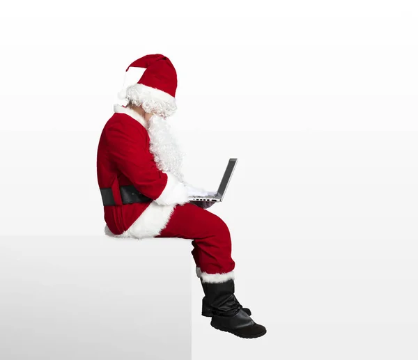 Weihnachtsmann Schaut Laptop Und Sitzt Auf Leerem Bildschirm — Stockfoto