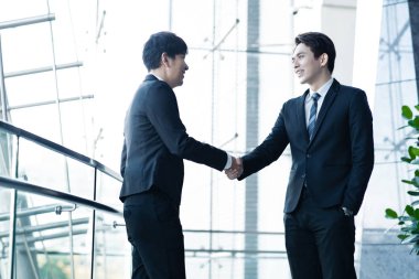 El sıkışan ve gülümseyen iki emin iş adamları 