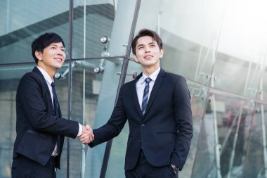 El sıkışan ve gülümseyen iki emin iş adamları 