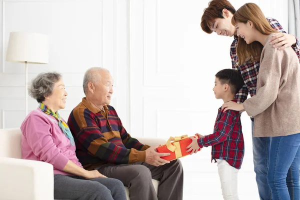 Cucu Dengan Orang Tua Memberikan Hadiah Kepada Kakek Nenek — Stok Foto