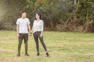 Mutlu genç gülümseyen çift ve şehir park eğlenmek