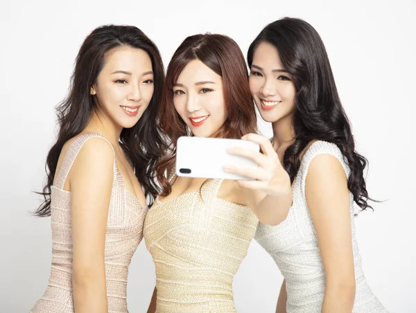 三个年轻的美女用智能手机拍照 — 图库照片