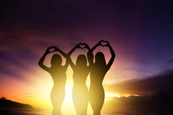 Tre Ragazze Silhouette Mani Facendo Forma Cuore Con Sfondo Tramonto — Foto Stock