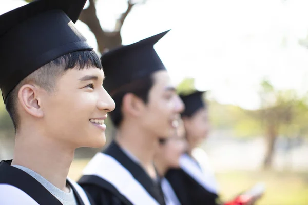 Leende asiatisk ung man vid examen — Stockfoto