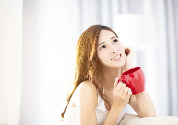 Young beautiful  woman drinking coffee on sofa — Stock Photo, Image