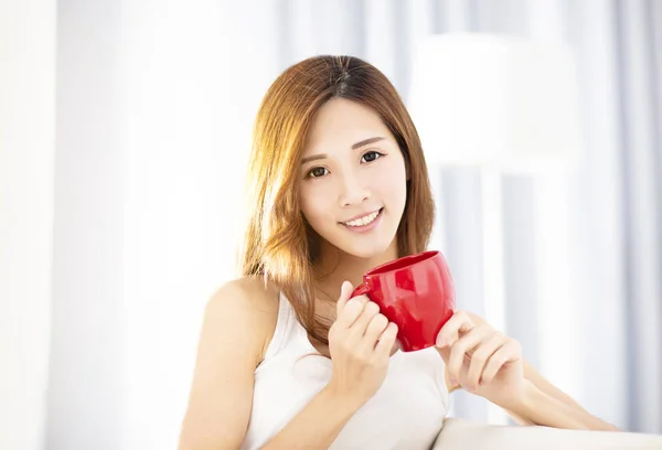 Young beautiful  woman drinking coffee on sofa — Stock Photo, Image