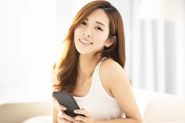 Vacker ung kvinna med smart telefon på soffa — Stockfoto