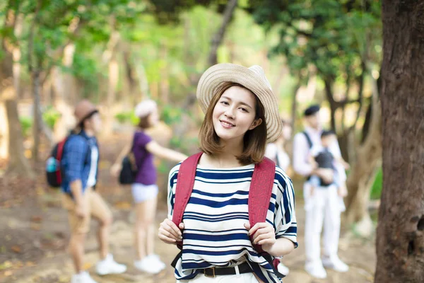 Lycklig kvinna med ryggsäck vandring i skogen — Stockfoto